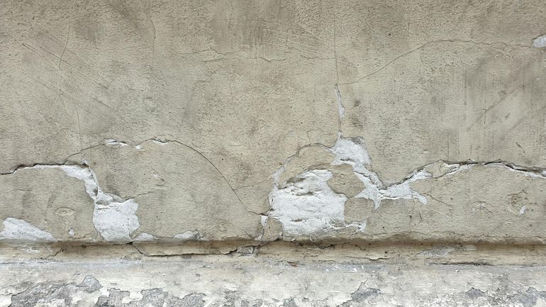 Глубокая трещина на бетонной стене как следствие неравномерной осадки фундамента