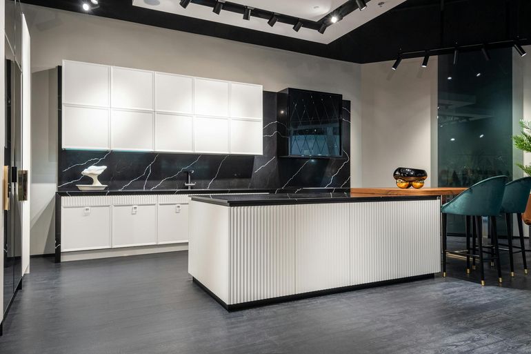 Современная кухня с белыми шкафами, тёмной столешницей и центральным островом