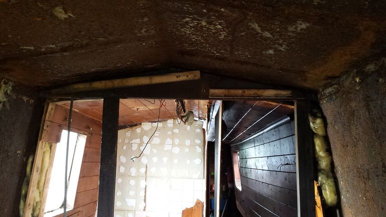 Рабочий обрабатывает поверхность стены перед нанесением раствора